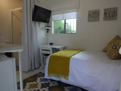 a bedroom with a bed with a yellow blanket on it at 273 Rhino retreat-solar backup in Centurion