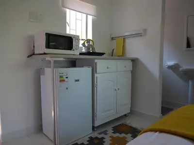 a small kitchen with a microwave and a refrigerator at 273 Rhino retreat-solar backup in Centurion