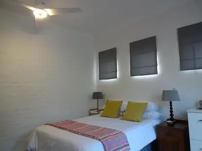 a bedroom with a white bed with green pillows at 273 Rhino retreat-solar backup in Centurion