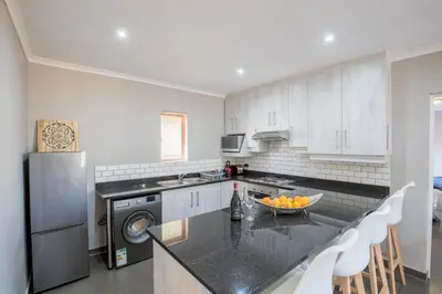 a kitchen with white cabinets and a black counter top at Greenwaywoods Unit 11 in White River