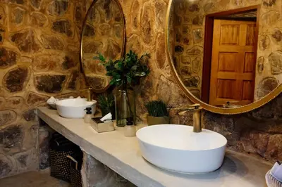a bathroom with a sink and a mirror at Dinkweng Safari Lodge in The Waterberg Biosphere