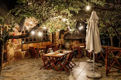 a table with an umbrella in a restaurant at Dinkweng Safari Lodge in The Waterberg Biosphere