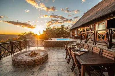 a patio with a table and a fire pit at Dinkweng Safari Lodge in The Waterberg Biosphere