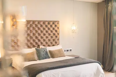 a bedroom with a large bed and a chandelier at Blue Diamond Boutique Hotel in Pretoria