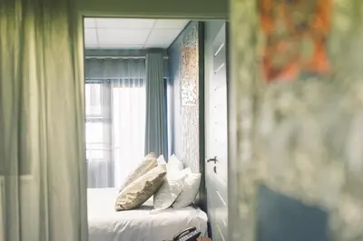 a mirror reflection of a bed in a bedroom at Blue Diamond Boutique Hotel in Pretoria