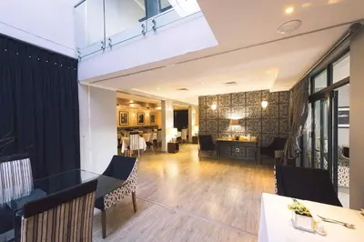a dining room and living room with a table and chairs at Blue Diamond Boutique Hotel in Pretoria