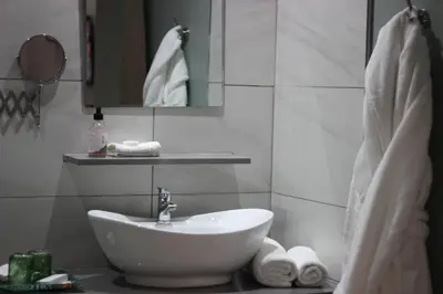 a white bathroom with a sink and a mirror at Ecolux Boutique Hotel in Komatipoort