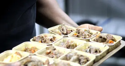 a person holding a tray of dishes of food at Ecolux Boutique Hotel in Komatipoort