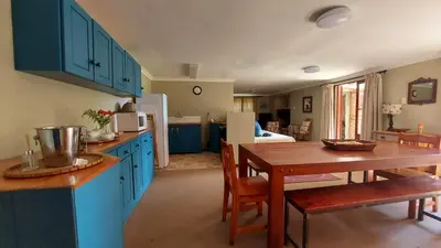 a kitchen with blue cabinets and a wooden table at Bluebell Cottage in Dullstroom