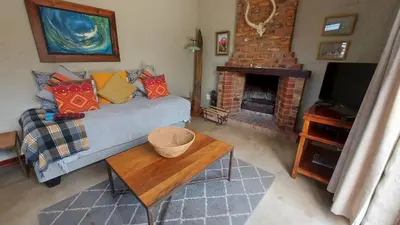 a living room with a couch and a fireplace at Bluebell Barn in Dullstroom