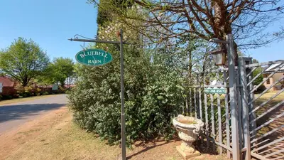 a street sign on a pole next to a fence at Bluebell Barn in Dullstroom