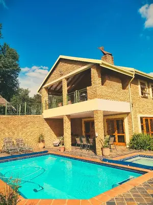 a swimming pool in front of a house at Cycad Place Midrand Guesthouse and B&B in Midrand