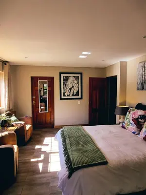 a bedroom with a large bed and a couch at Cycad Place Midrand Guesthouse and B&B in Midrand