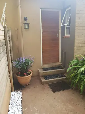 a front door of a house with a pot of flowers at Love Joy Peace Cottage in Pretoria