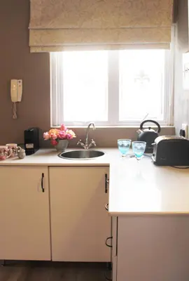 a kitchen with a sink and two glasses on a counter at BELLA ROSA FARM in Midrand