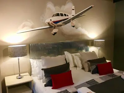 a plane hanging on the wall above a bed at Morgenzon Estate in Pretoria