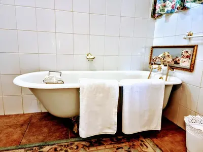 a bathroom with a white tub with towels on it at Mia's in Tzaneen