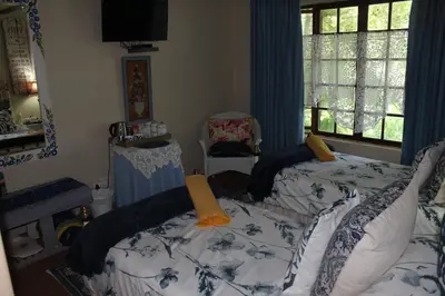 a bedroom with two beds and a window at Mia's in Tzaneen