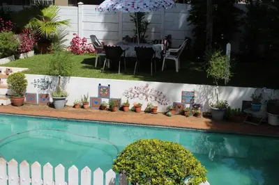 a swimming pool with a table and chairs and plants at Mia's in Tzaneen