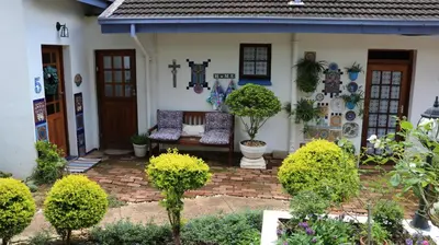 a house with a bench in the front yard at Mia's in Tzaneen