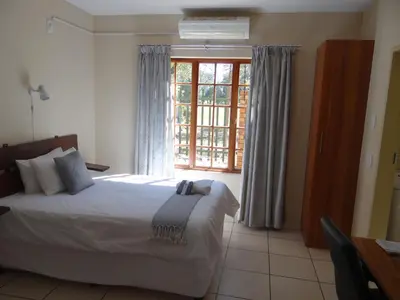 a bedroom with a large bed and a window at Lepha Guest House in Onverwacht