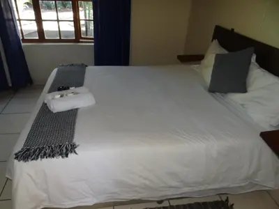 a large white bed with two towels on it at Lepha Guest House in Onverwacht
