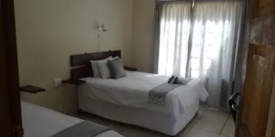 a bedroom with a large bed and a window at Lepha Guest House in Onverwacht