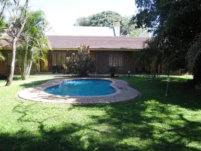 a small swimming pool in the yard of a house at Lepha Guest House in Onverwacht