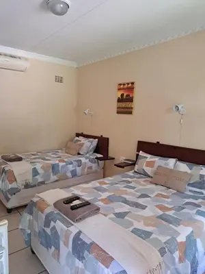 two beds in a hotel room with at Lepha Guest House in Onverwacht