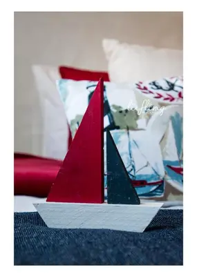 a red and white paper boat sitting on a bed at Anchor Guesthouse in Secunda