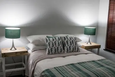 a bedroom with a bed with two lamps on tables at Anchor Guesthouse in Secunda