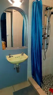 a bathroom with a sink and a blue shower curtain at Eagle's Nest in Barberton