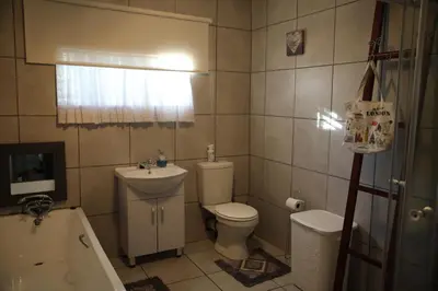 a bathroom with a toilet and a sink and a tub at Eagle's Nest in Barberton