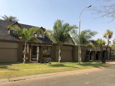 a house with palm trees and a street light at Annies Place Self Catering in Kempton Park