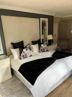 a bedroom with a large white bed with pillows at Annies Place Self Catering in Kempton Park