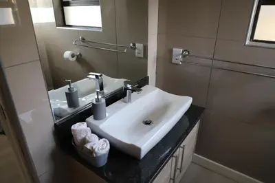 a bathroom with a sink and a mirror at Memories Made Cottage in Kampersrus AH