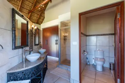 a bathroom with a sink and a toilet at Zebula - HT1 - 5 Bedroom Holiday Home in Mabula