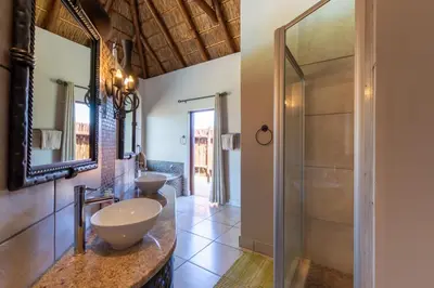 a bathroom with two sinks and a shower at Zebula - HT1 - 5 Bedroom Holiday Home in Mabula