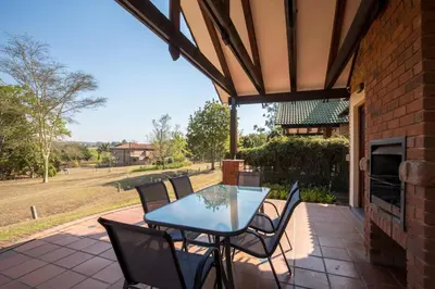 a patio with a table and chairs on a patio at Unit 12, Greenway Woods, White River in Die Winkler