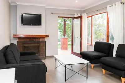 a living room with two couches and a fireplace at Unit 12, Greenway Woods, White River in Die Winkler
