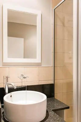 a bathroom with a white tub and a mirror at Unit 12, Greenway Woods, White River in Die Winkler