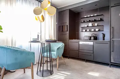 a kitchen with a table and some blue chairs at The Hideaway in Benoni