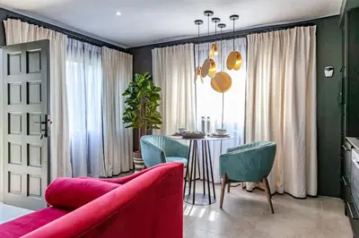 a living room with a red couch and a table with chairs at The Hideaway in Benoni