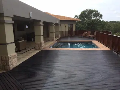 a swimming pool on a deck next to a house at Elements golf reserve in Bela-Bela