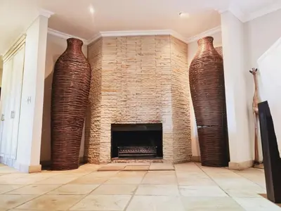three tall vases in a living room with a fireplace at Elements golf reserve in Bela-Bela