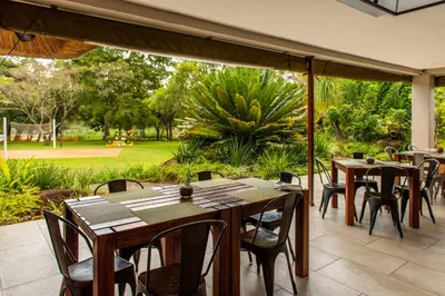 an outdoor patio with wooden tables and chairs at Kruger Park Lodge Unit No. 239 in Hazyview