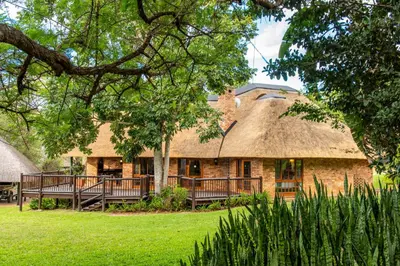 a thatch roofed house with a thatched roof at Kruger Park Lodge Unit No. 239 in Hazyview