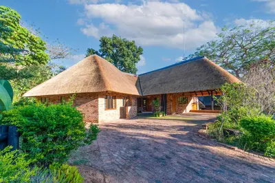 a house with a thatched roof and a driveway at Kruger Park Lodge Unit No. 239 in Hazyview