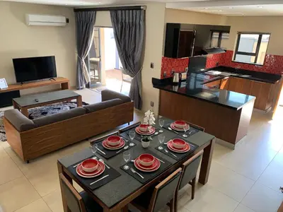 a living room with a table with red dishes on it at 66 Dorp Street Apartment in Polokwane