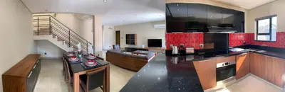 a kitchen and living room with a counter top and a staircase at 66 Dorp Street Apartment in Polokwane